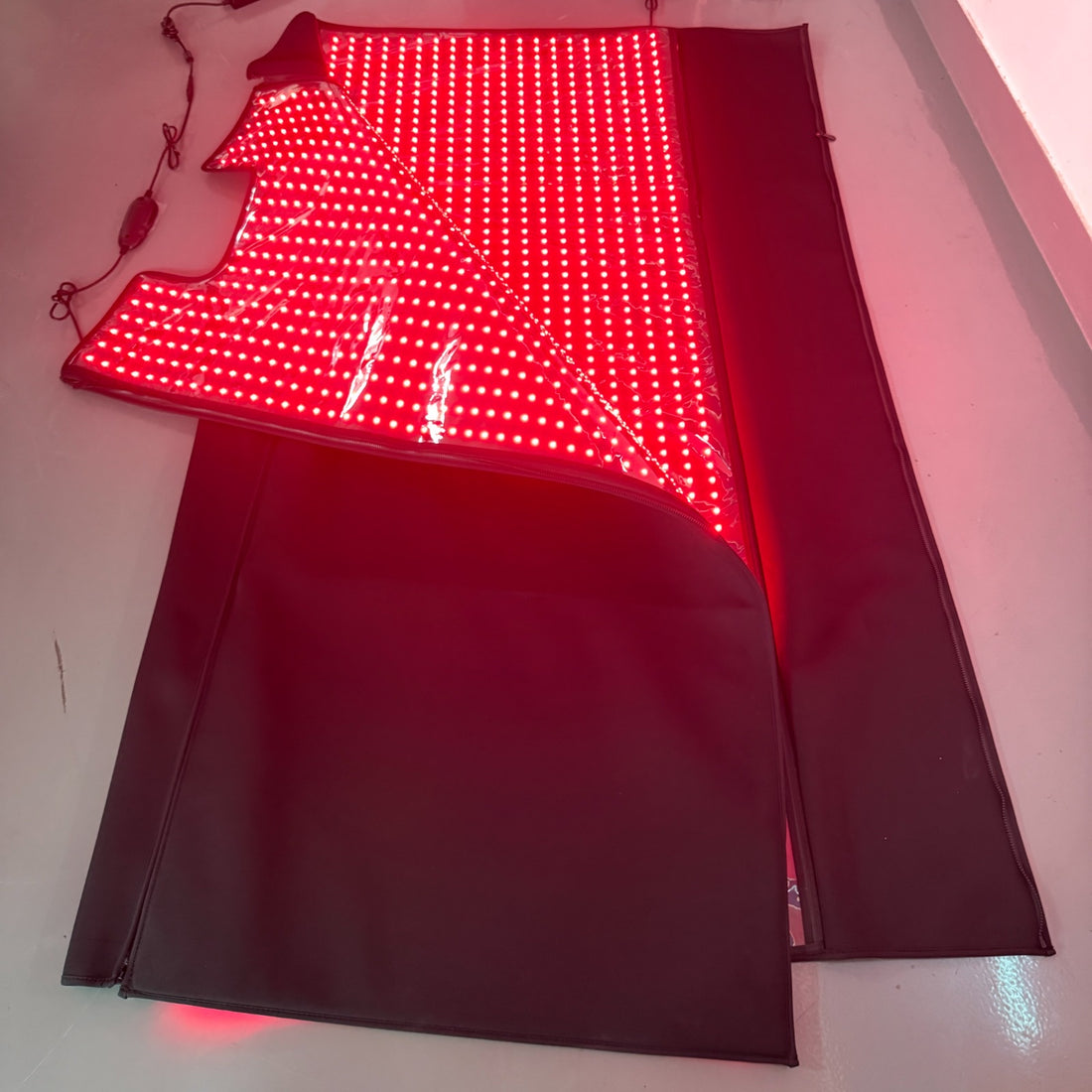 Red Light+ Blanket with the top panel folded back along its hinge, the lit panel inside