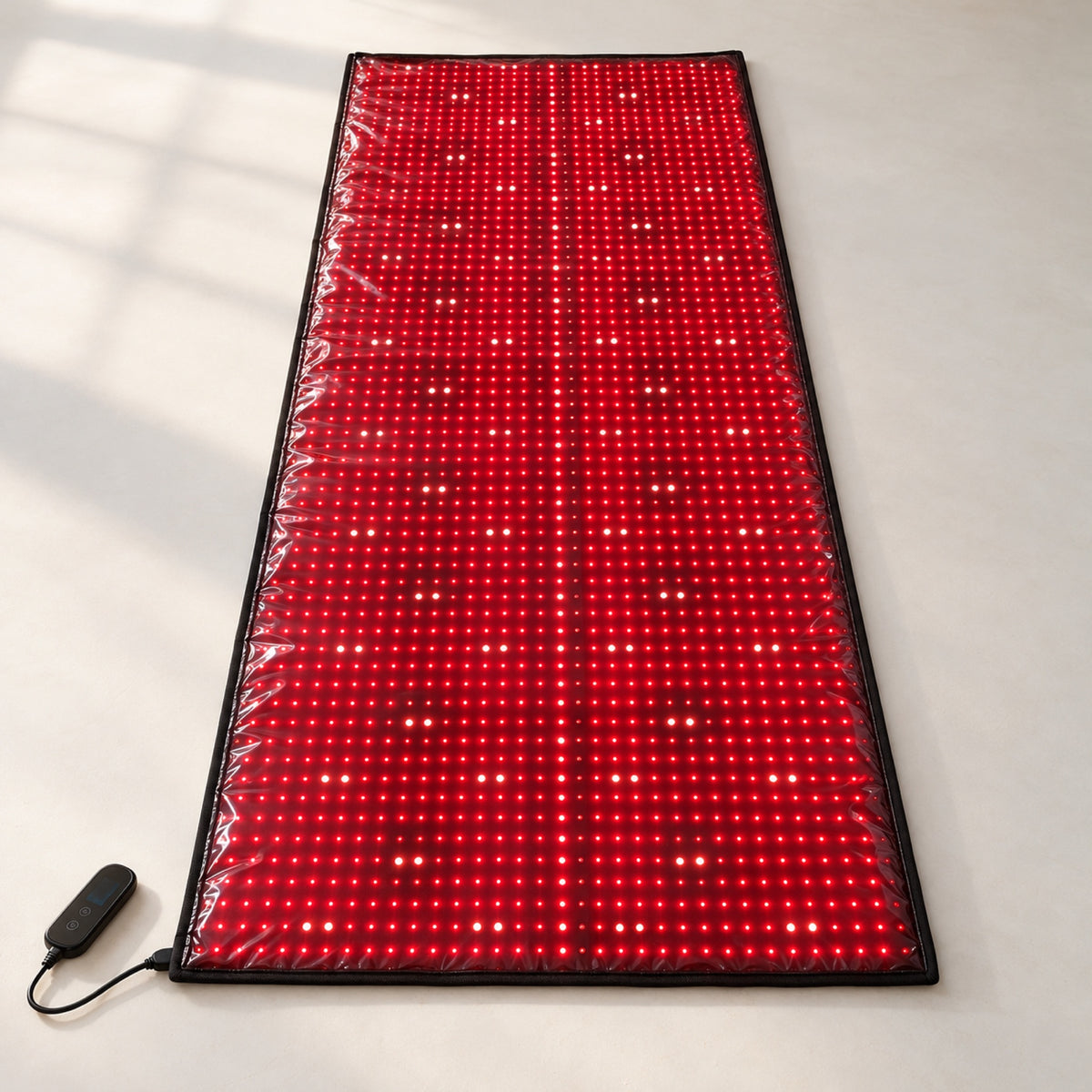 Red Light+ Laser Mat lit on a studio floor, the laser modules showing as brighter points down the center and in pairs